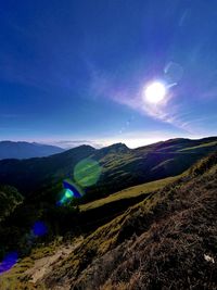 Scenic view of landscape against bright sun