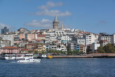 Buildings by sea against sky in city