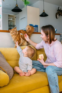 Mom feeds a small child at home with yogurt from a spoon. family concept