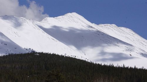 Low angle view of snowcapped mountains against sky