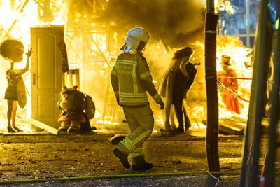 Firefighters by fire at night