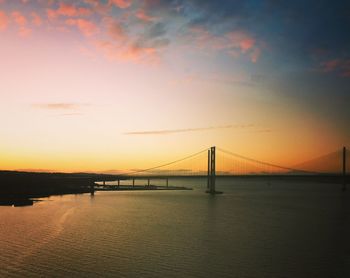 Bridge over sea against sky during sunset