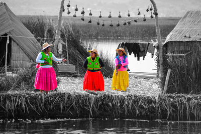 Rear view of women standing by lake