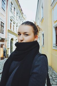 Portrait of young woman standing in alley