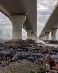 Bridge over rocks against sky
