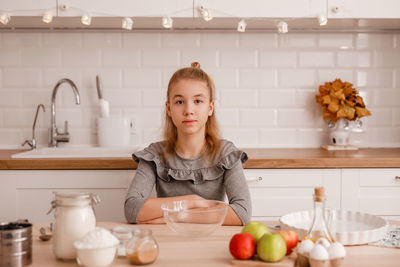 Portrait of cute girl standing at kitchen