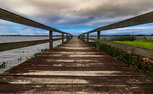 View of empty footpath leading towards water