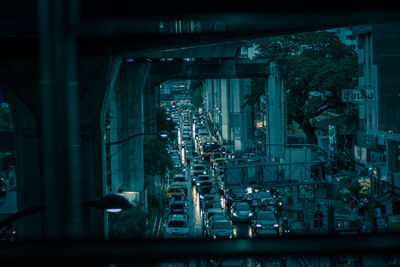 High angle view of illuminated city seen through window at night