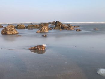 View of rocks on beach against sky