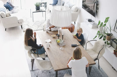 High angle view of family sitting at table in living room