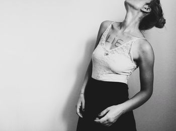 Midsection of woman standing against white background