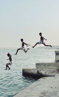 Rear view of woman jumping in sea
