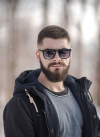 Portrait of young man wearing sunglasses standing outdoors