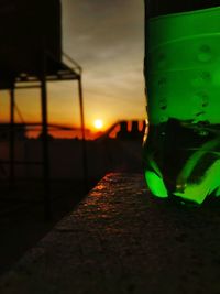 Close-up of beer glass on table against sky during sunset