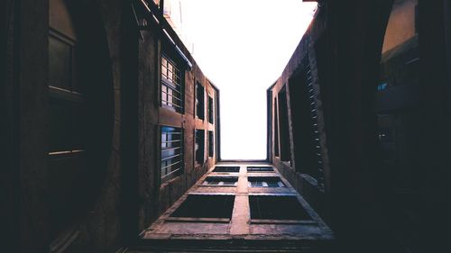 Directly below shot of narrow alley amidst buildings in city