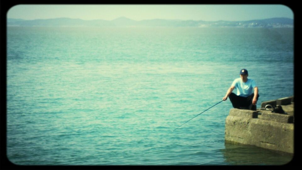 sea, water, transfer print, horizon over water, lifestyles, leisure activity, auto post production filter, sky, young adult, beauty in nature, full length, scenics, nature, sitting, tranquil scene, men, tranquility, nautical vessel