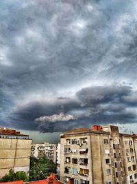 Low angle view of buildings against cloudy sky