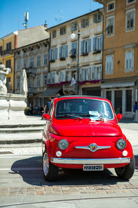 Car on street against buildings in city