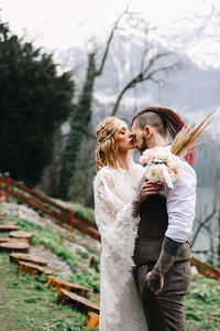 A happy couple in love and married embrace in nature by the lake and the misty mountains