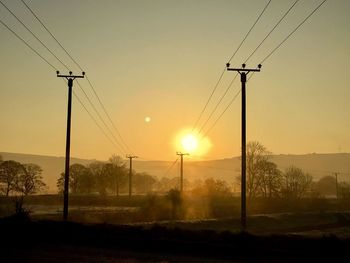 Wind turbines against sky during sunset