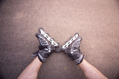 Low section of man with roller skates lying on floor