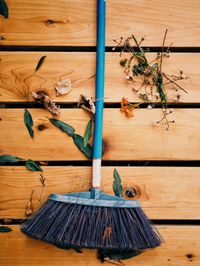 High angle view of broom and leaves on wooden floor