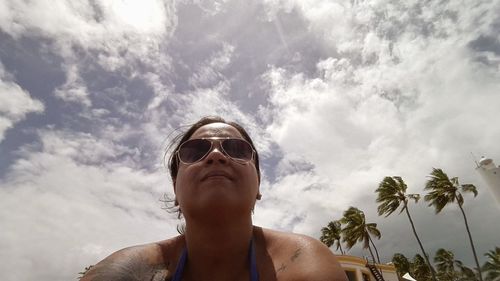 Low angle view of woman against cloudy sky