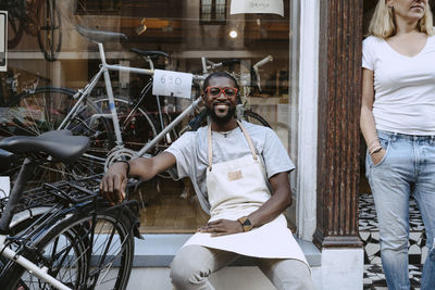 Young man and woman standing by bicycle