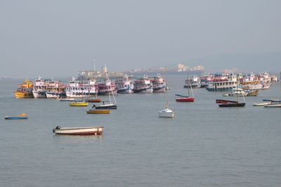 Boats moored in sea against clear sky