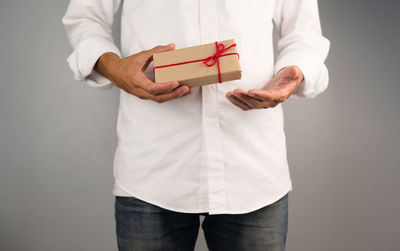 Midsection of a man holding hands against white background