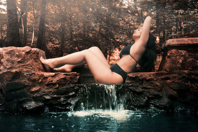 Side view of young woman relaxing in water