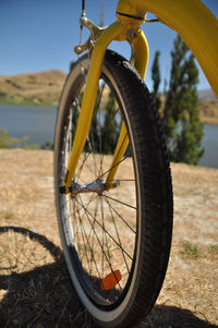 Close-up of bicycle wheel at lakeshore