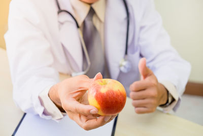 Midsection of woman holding apple