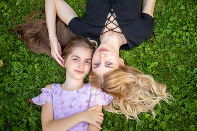 High angle view of young woman lying on grassy field