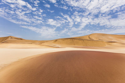 Sand dunes in desert against sky