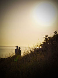 Silhouette of couple sitting on beach