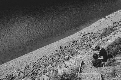 High angle view of couple sitting by sea