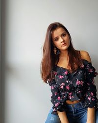 Portrait of beautiful woman standing against wall