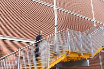 Businessman walking up on staircase near building