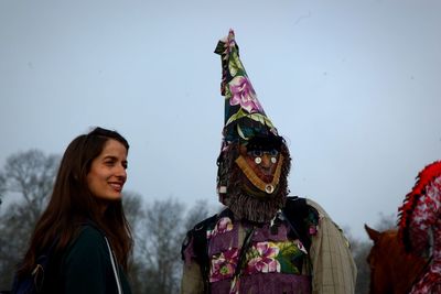 Young woman with arms raised against sky