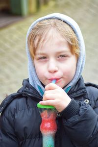 Portrait of boy drinking juice in city