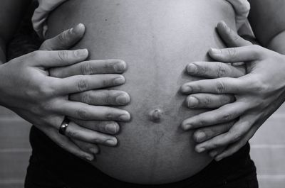 Midsection of couple touching hands