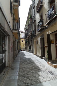 Street amidst houses against sky in city