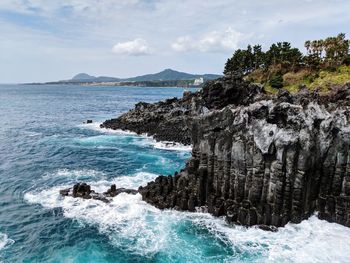 Scenic view of rocks in sea against sky