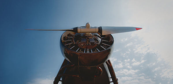 Low angle view of clock on airplane against sky