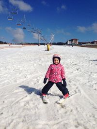 Portrait of girl skiing on snow against sky