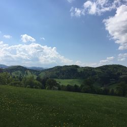 Scenic view of grassy field against cloudy sky