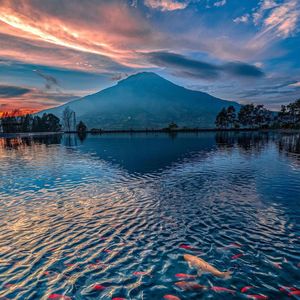 Scenic view of lake and mountains against sky during sunset