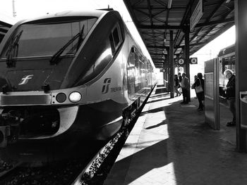 People at railway station against sky