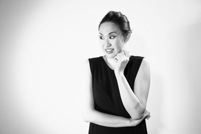 Portrait of smiling young woman against white background